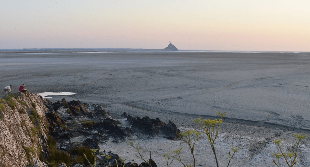 Baie à marée basse du Mont-Saint-Michel pendant un coucher de soleil